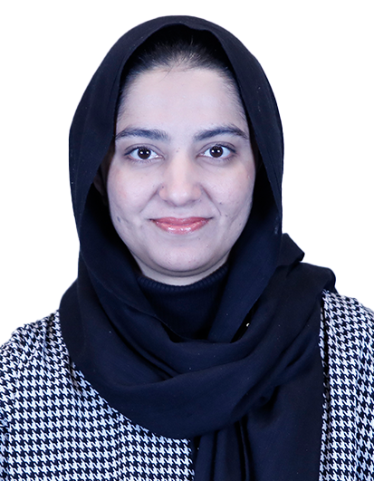 Portrait of a woman in a black hijab and houndstooth-pattern jacket, smiling at the camera.