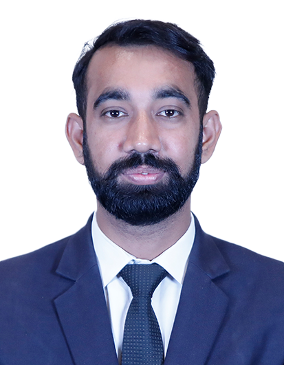 Professional headshot of a man with a beard in a navy suit and black tie against a white background.